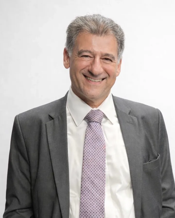 Retrato do advogado Ronaldo Gotlib, sorrindo, de terno cinza